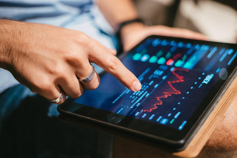 Man holding a tablet showing market trend